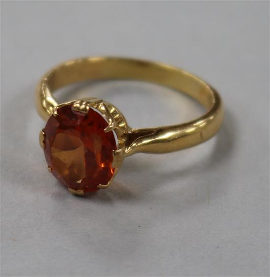 A yellow metal and orange sapphire ring, size O